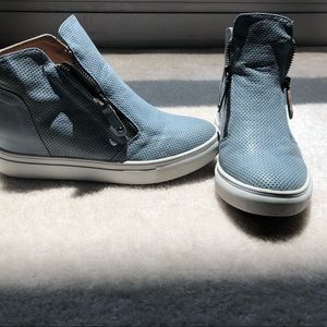 Blueish-grey high top sneakers.